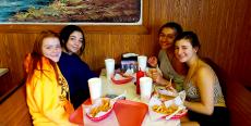 Friends enjoying french fries at Nick's Drive-In Restaurant in Chicago